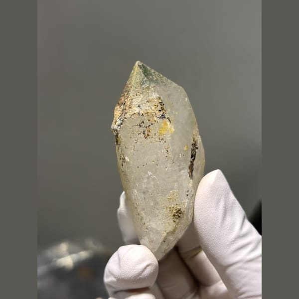 Chunky quartz point with green and rusty inclusions from Tibet — detail view