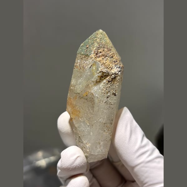 Chunky quartz point with green and rusty inclusions from Tibet — detail view