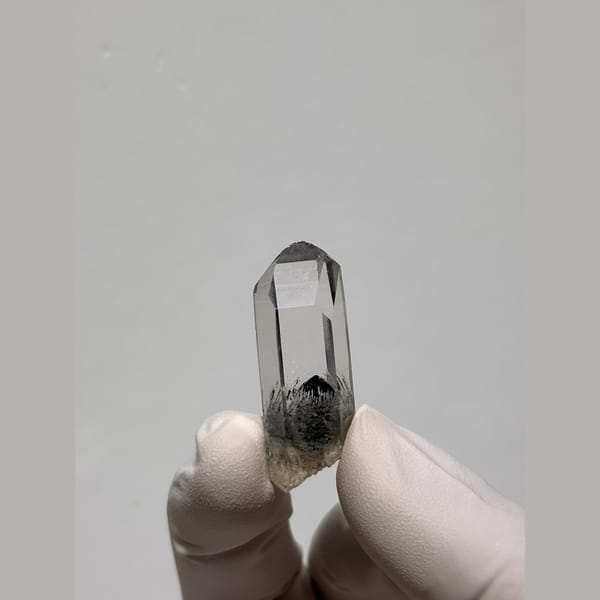Clear quartz point with a dark inclusion from Jinkouhe — complete view