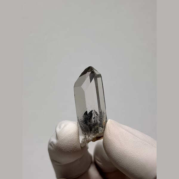 Clear quartz point with a dark inclusion from Jinkouhe — detail view