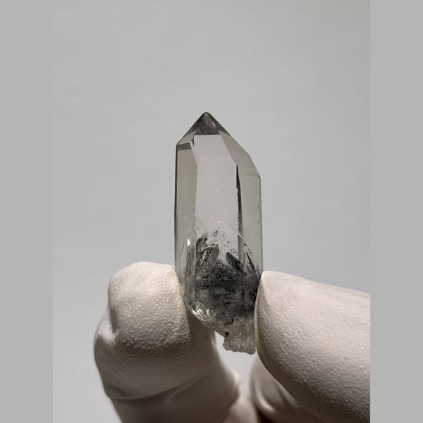 Small clear quartz point with dark inclusions from Jinkouhe — alternate view