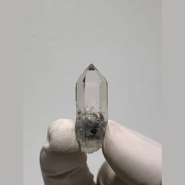 Small clear quartz point with dark inclusions from Jinkouhe — alternate view