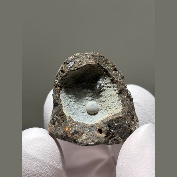 Tiny calcite pearl in a frosty matrix pocket from Zhejiang — alternate view