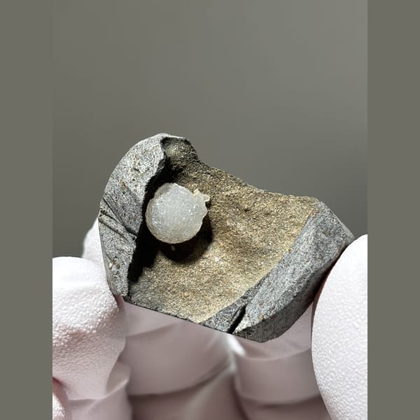 White calcite ball in grey matrix from Zhejiang — complete view