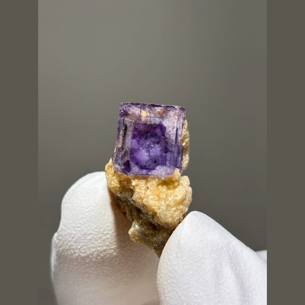 Deep purple fluorite cube on golden mica from Yaogangxian — complete view