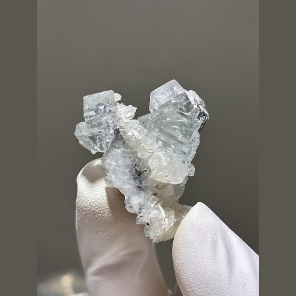 Pale blue fluorite crystals on white quartz — complete view