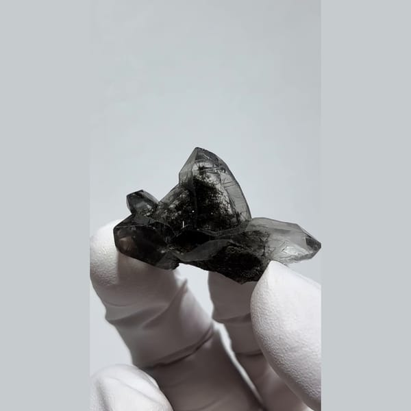 Small smoky quartz cluster with dark hair-like inclusions from Pakistan — alternate view