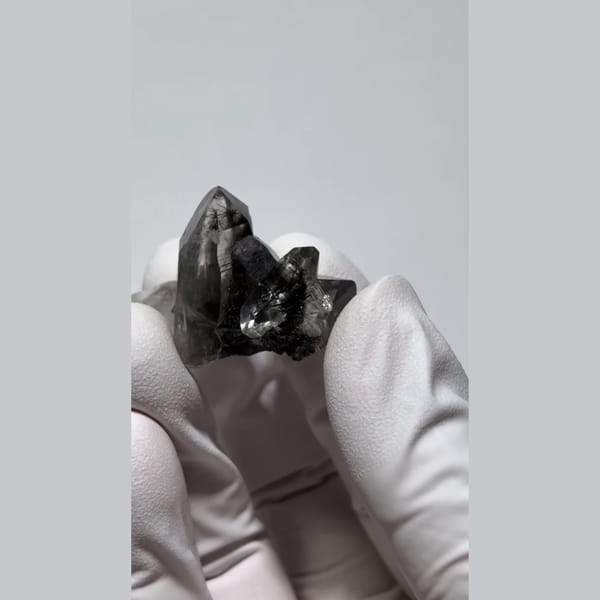 Small smoky quartz cluster with dark hair-like inclusions from Pakistan — alternate view