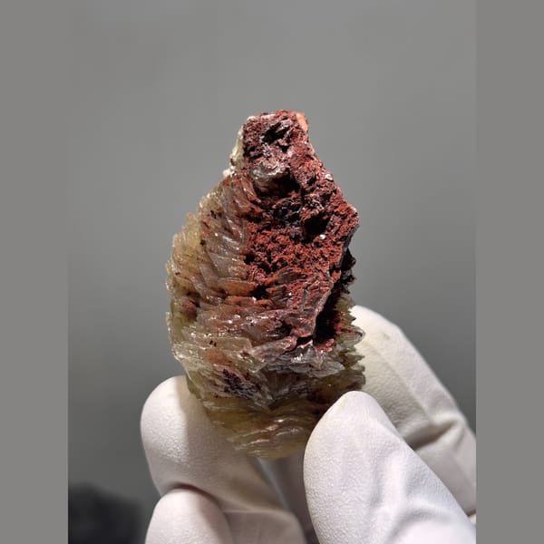 Layered honey yellow calcite on red matrix from Hubei — detail view