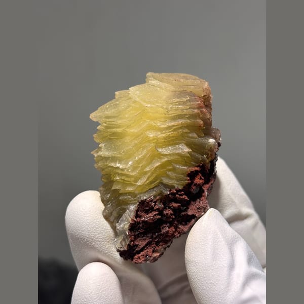 Layered honey yellow calcite on red matrix from Hubei — detail view