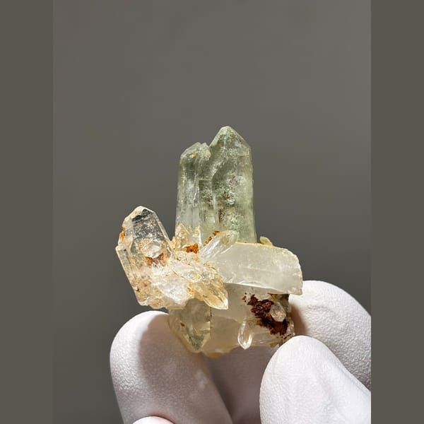 Small pale quartz cluster with rusty spots from Tibet — alternate view