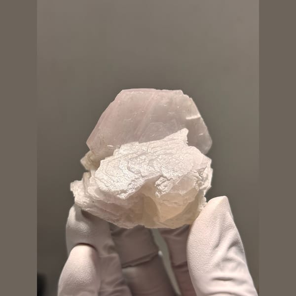 Creamy white calcite with salmon pink UV glow from Fujian — complete view