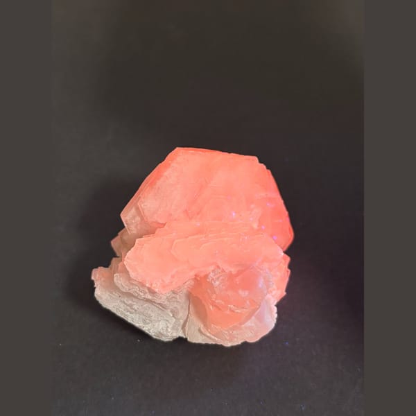 Creamy white calcite with salmon pink UV glow from Fujian — detail view