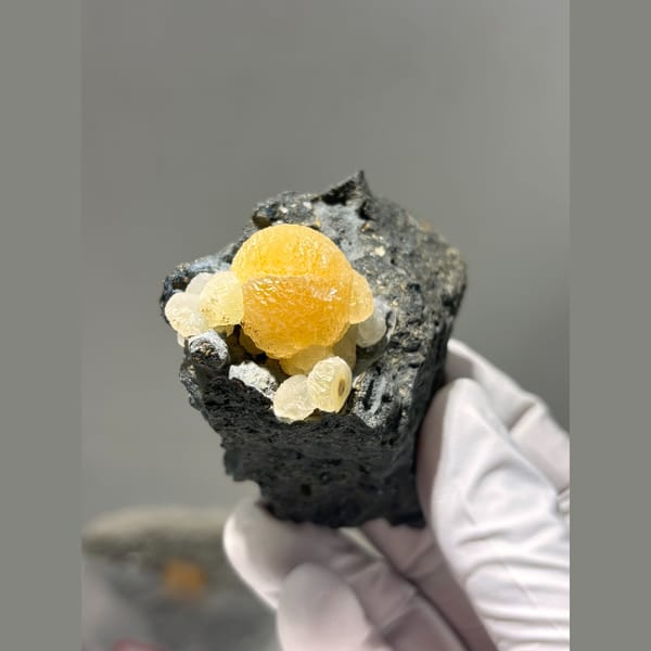 Bright yellow calcite sphere in dark matrix from Zhejiang — alternate view