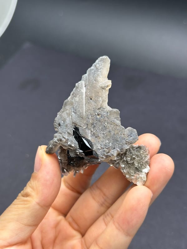 Complete reverse view of the broad stepped calcite blade with cassiterite and mica beneath