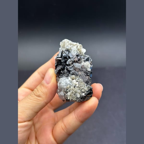 Pale blue aquamarine with black cassiterite from Xuebaoding, Sichuan — detail view