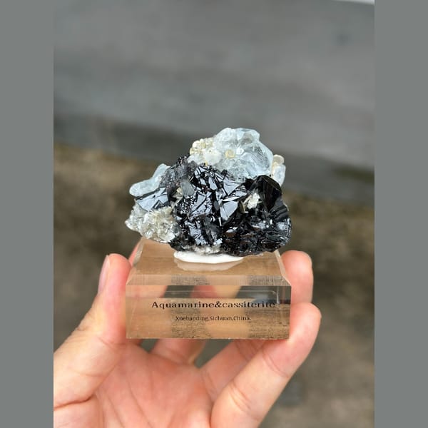 Pale blue aquamarine with black cassiterite from Xuebaoding, Sichuan — detail view