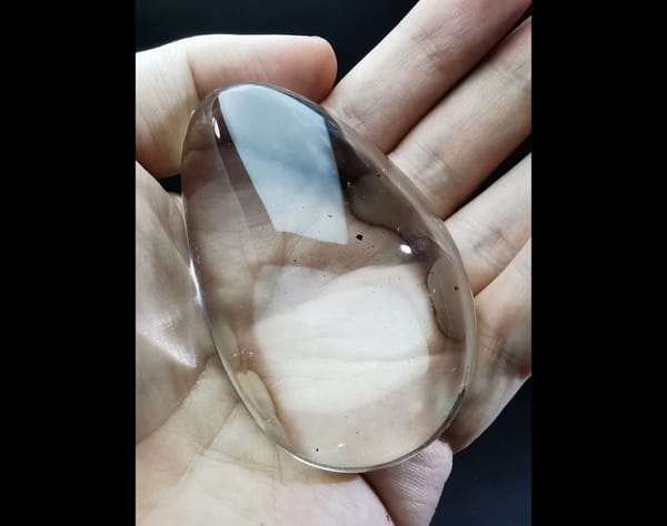 Complete front view of the exact polished clear quartz palm stone