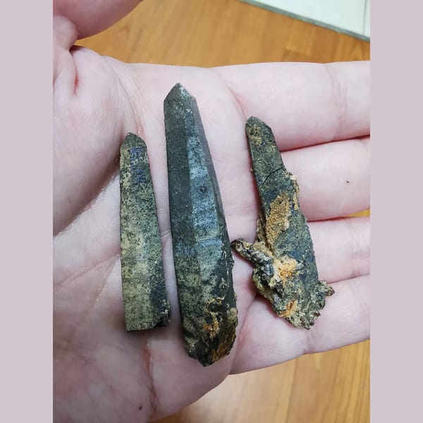 Three black-green quartz crystals — complete view