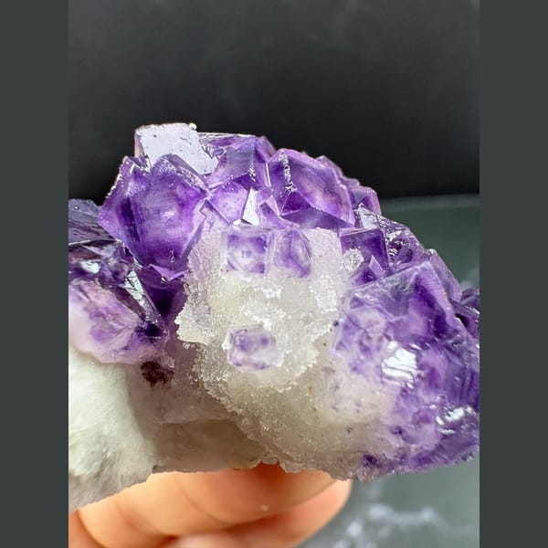 Purple fluorite with pale-windowed faces on white quartz from Henan — alternate view