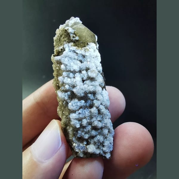 Quartz crystal covered in sparkling fluorite — complete view