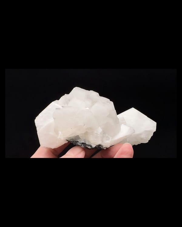 Complete front of layered white calcite crystals on a dark matrix, Fujian China