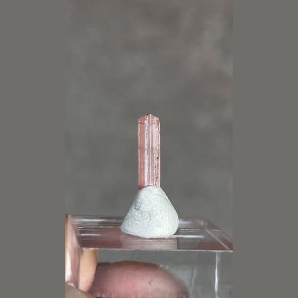 Tiny pale pink väyrynenite crystal from Pakistan on a stand — detail view