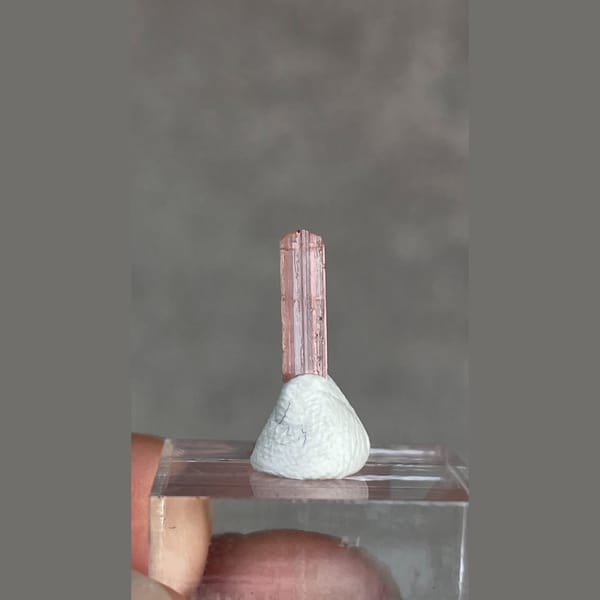 Tiny pale pink väyrynenite crystal from Pakistan on a stand — detail view