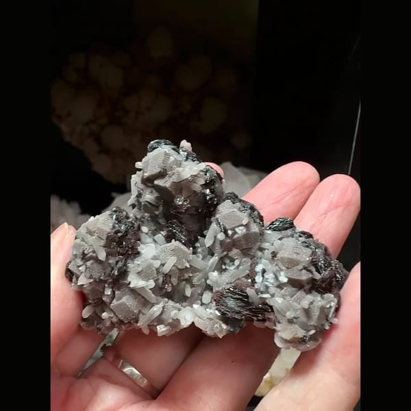Dark andradite garnet with bladed hematite and grey-pink calcite from Inner Mongolia — detail view