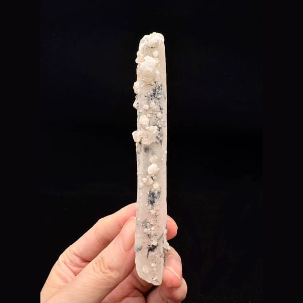 Slender quartz floater with pale pink calcite and specular hematite from Inner Mongolia — alternate view