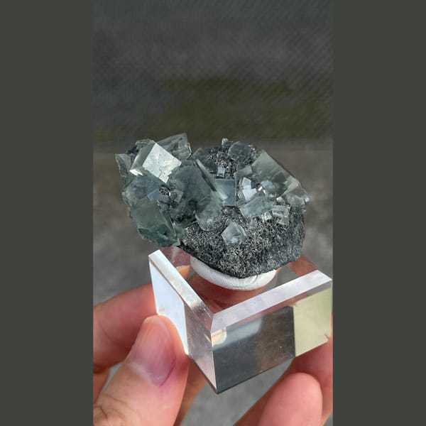 Transparent teal fluorite crystals on dark matrix from Hunan — detail view