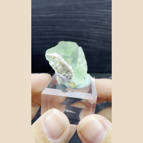 Glassy jelly-green fluorite crystal on an acrylic stand from Chifeng, Inner Mongolia — alternate view