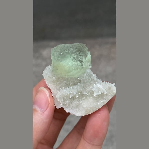 Stepped mint-green fluorite cube on white quartz from Fujian — detail view