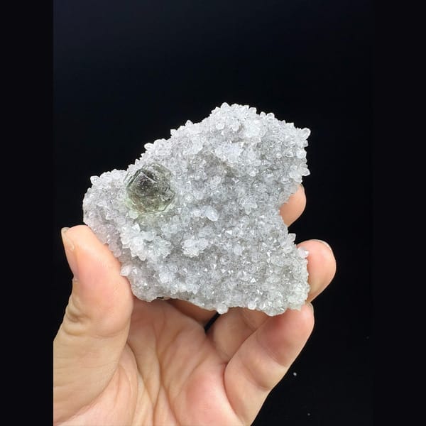 Pale green fluorite crystal in sparkling white quartz druse from Fujian — complete view