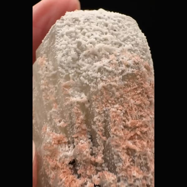 Pinkish-white coated quartz crystal with black specular hematite from Inner Mongolia — detail view