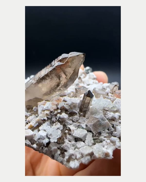 Complete left oblique view of smoky quartz with hyalite and feldspar