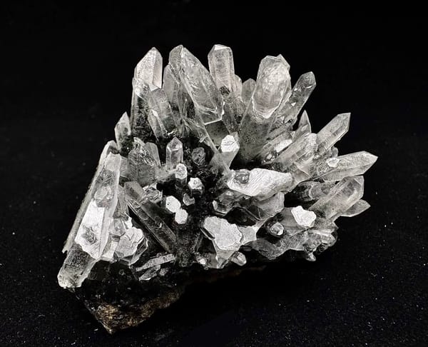 Complete upright view of the same quartz cluster and dark host base