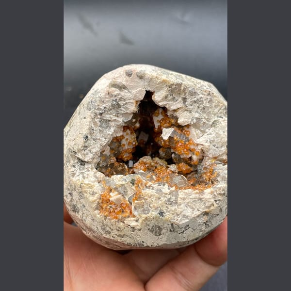 Geode lined with orange spessartine garnet, dolomite and smoky quartz from Yunxiao, Fujian — complete view