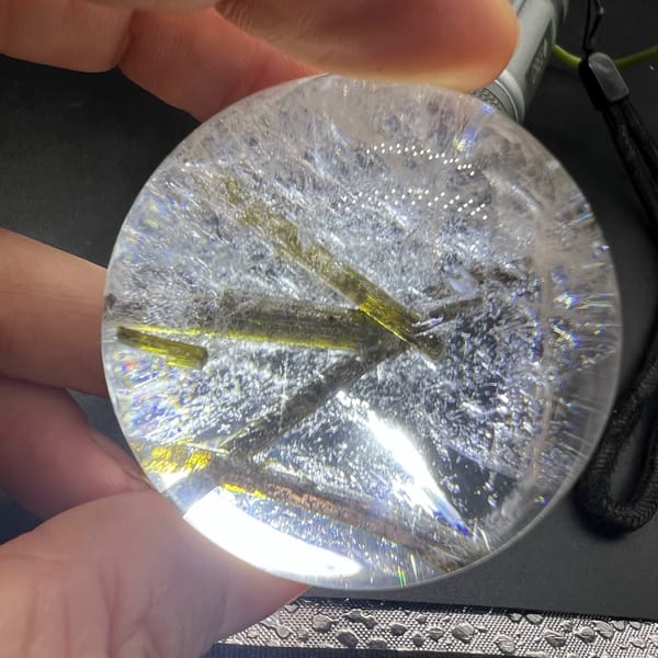 Clear quartz sphere with green tourmaline inclusions — alternate view