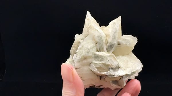 Complete side view of the same Fujian calcite specimen, showing upright blades above the broad layered base
