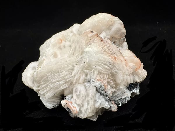Raised complete front view showing stacked white calcite blades with pale pink bands