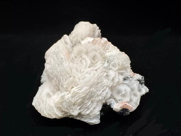 Complete reverse showing broad calcite fans and reflective hematite at the base