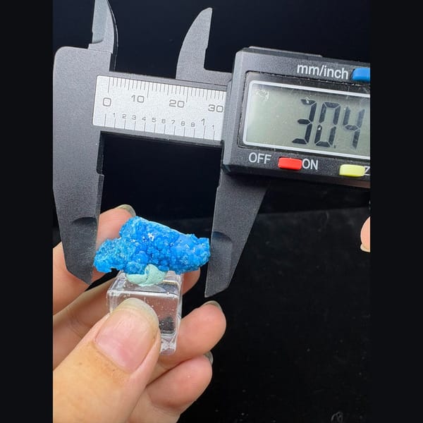 Bright blue frothy allophane from Qinglong, Guizhou on a stand — alternate view
