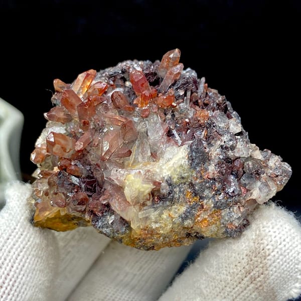 Red-orange quartz points on dark specular hematite from Guangdong — complete view