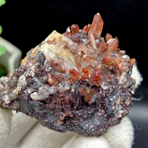 Red-orange quartz points on dark specular hematite from Guangdong — alternate view
