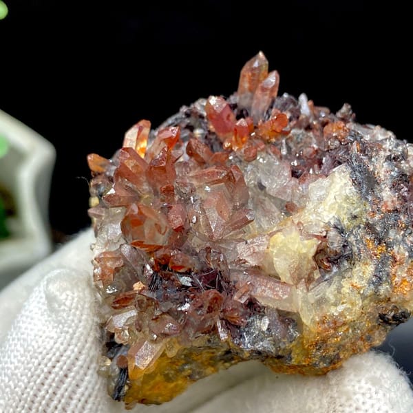 Red-orange quartz points on dark specular hematite from Guangdong — alternate view