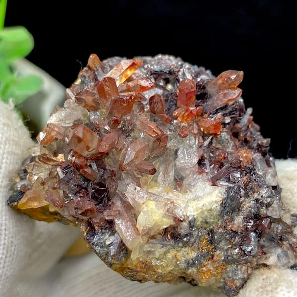 Red-orange quartz points on dark specular hematite from Guangdong — detail view