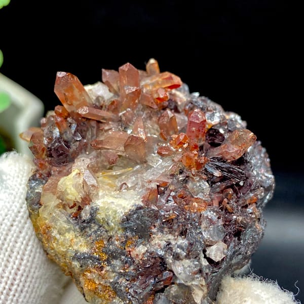Red-orange quartz points on dark specular hematite from Guangdong — detail view
