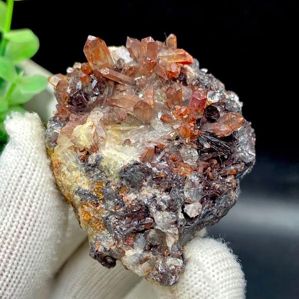 Red-orange quartz points on dark specular hematite from Guangdong — detail view