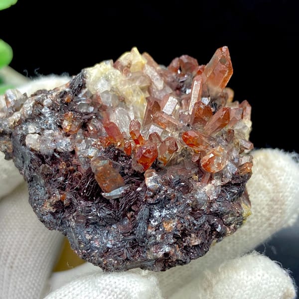 Red-orange quartz points on dark specular hematite from Guangdong — detail view